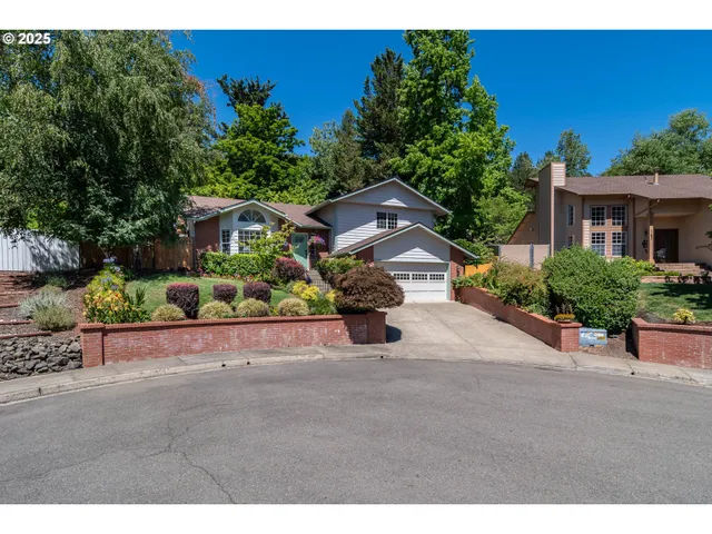 a view of a street with potted plants and a bench
