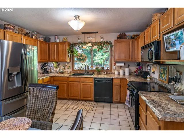 a kitchen with stainless steel appliances granite countertop a stove a sink dishwasher and a refrigerator