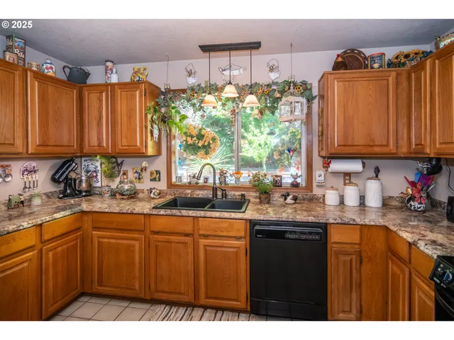 a kitchen with stainless steel appliances granite countertop a sink a stove and cabinets