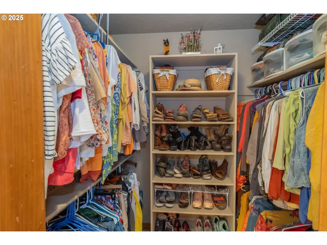 a view of walk in closet with clothes and shoes