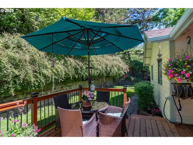 a view of a chairs and table under an umbrella in the balcony