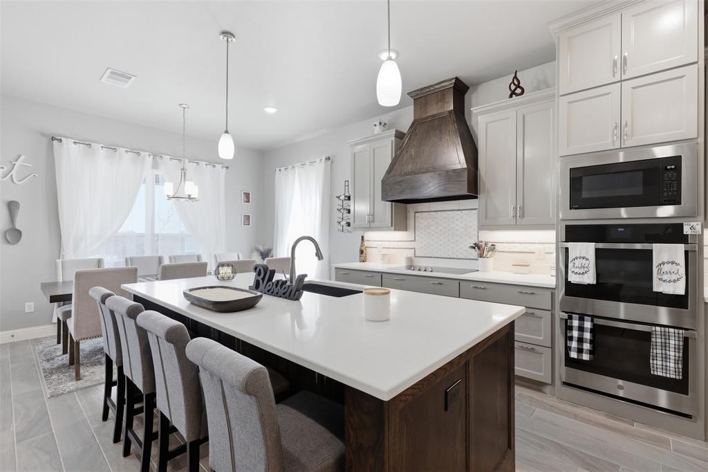 3036 Deer Path Weatherford, TX 76085 - Photo 9 of 35 a kitchen with stainless steel appliances a table chairs refrigerator and microwave