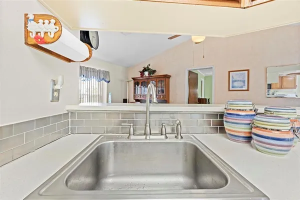 a kitchen with stainless steel appliances kitchen island granite countertop a stove top oven a sink a dining table and chairs
