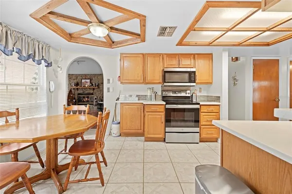 a kitchen with stainless steel appliances granite countertop a dining table and chairs