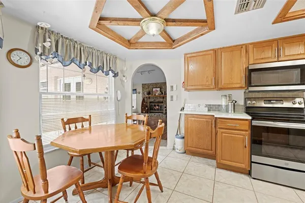 a kitchen with stainless steel appliances a table chairs and a refrigerator