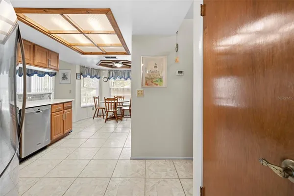 a kitchen with a table chairs refrigerator and cabinets