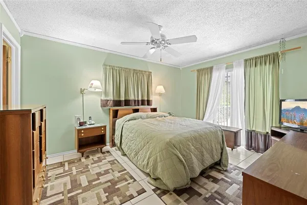 a bedroom with a large bed and a chandelier