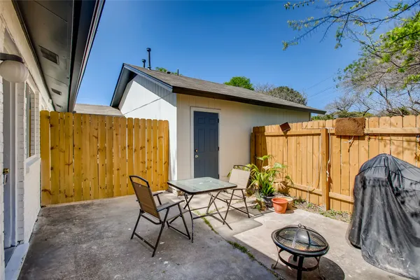 a backyard of a house with table and chairs
