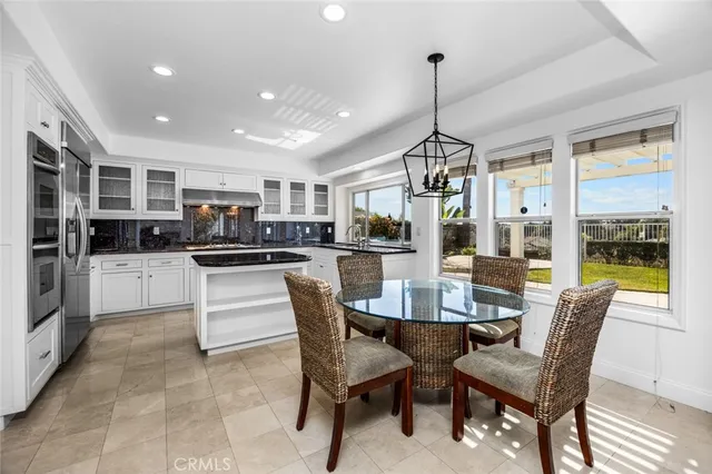 a dining room with furniture a kitchen and chandelier