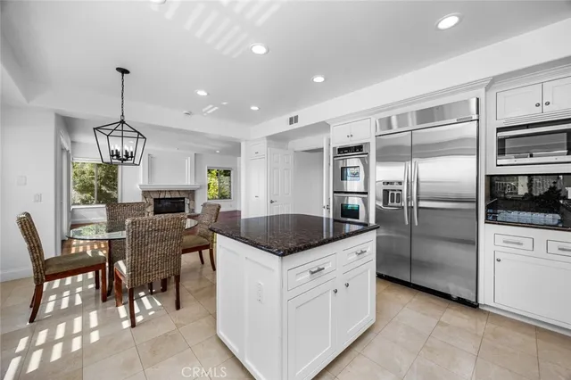 a kitchen with granite countertop stainless steel appliances a refrigerator and a dining table