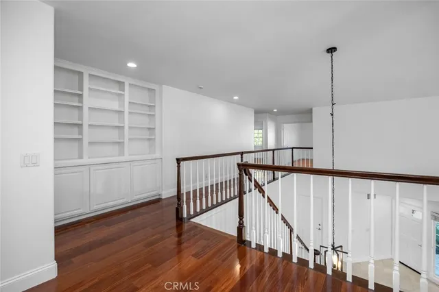 a view of a hallway with wooden floor and stairs