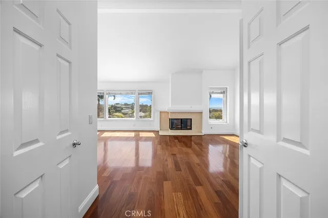 a view of empty room with wooden floor and fireplace