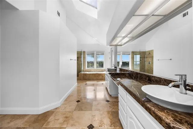a bathroom with a granite countertop sink a mirror and a bathtub