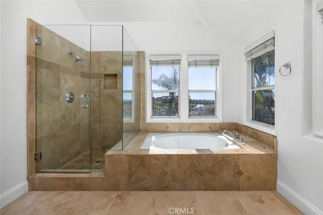 a bathroom with a tub shower and window