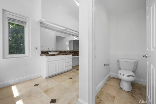 a white toilet sitting next to a bathroom sink