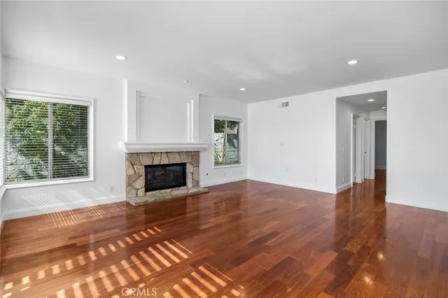 a view of a livingroom with a fireplace wooden floor and window