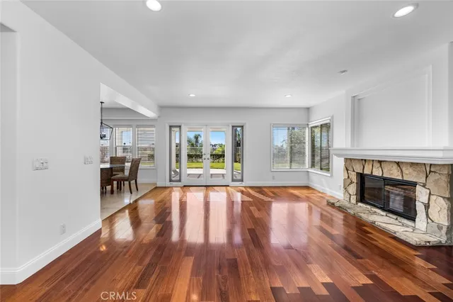 a view of empty room with fireplace and wooden floor