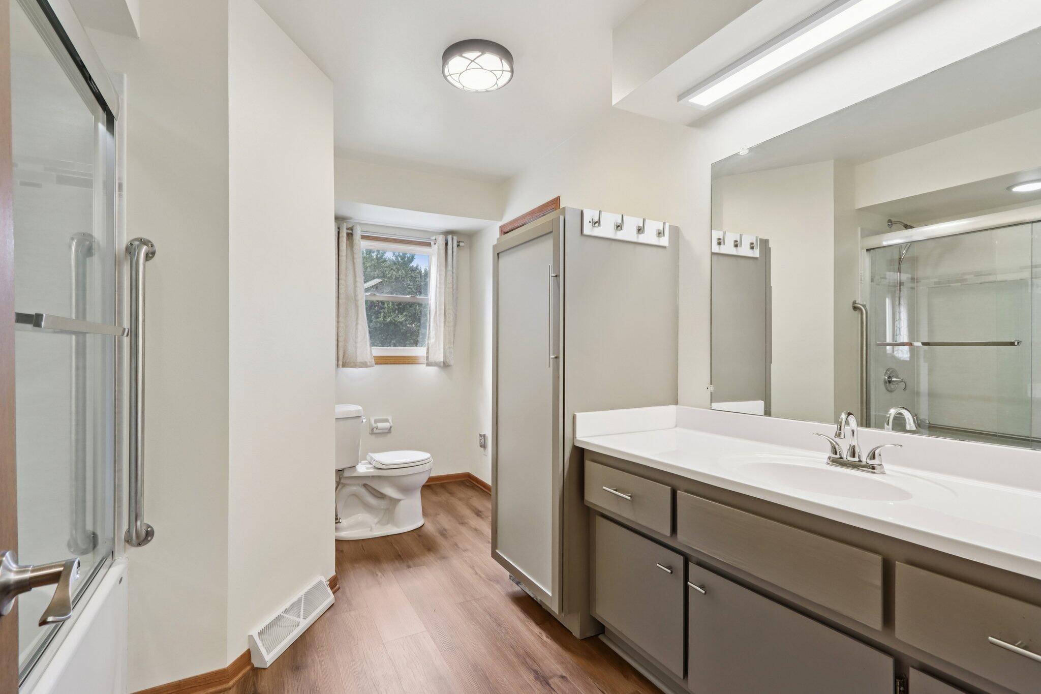 901 Anton Road Hartland, WI 53029 - Photo 21 of 48 Spacious main bath features a beautiful tub/shower unit, generous vanity and linen storage.