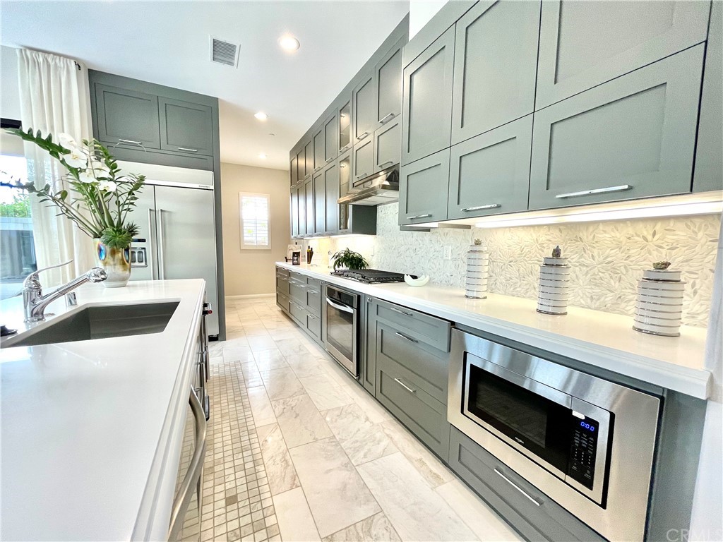 20744 Bur Oak Circle Porter Ranch, CA 91326 - Photo 6 of 36 a kitchen with stainless steel appliances kitchen island granite countertop a sink and a stove