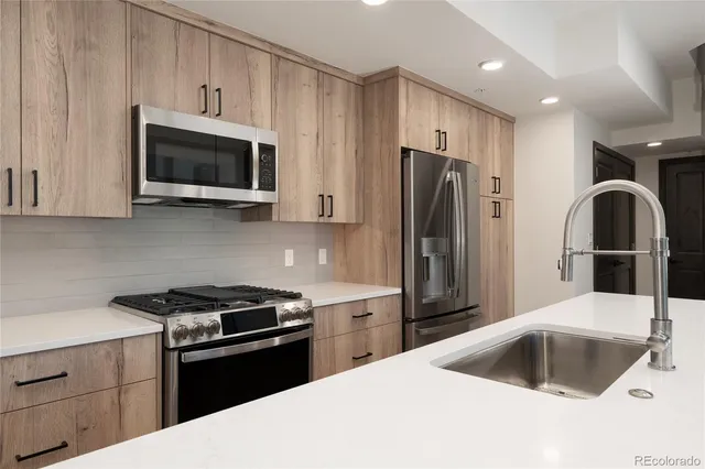a kitchen with stainless steel appliances granite countertop a refrigerator sink and microwave