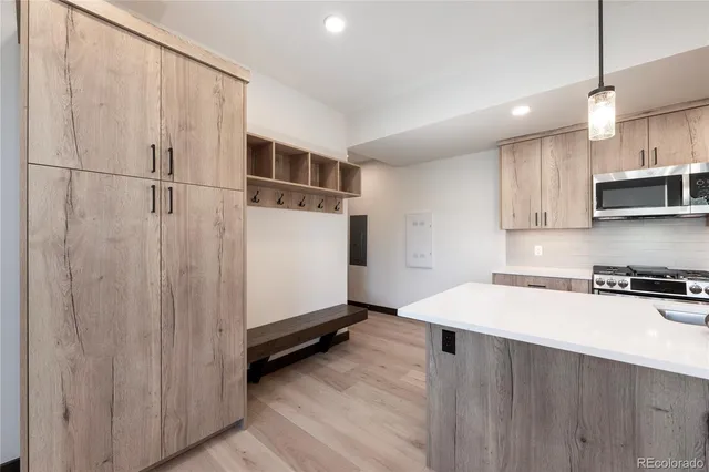 a kitchen with granite countertop a refrigerator a sink and white cabinets