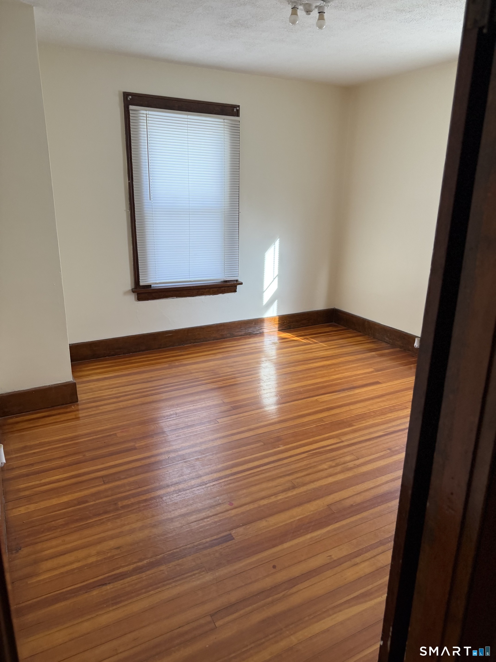 5 Gardners Lane Ansonia, CT 06401 - Photo 5 of 8 a view of an empty room with wooden floor and a window