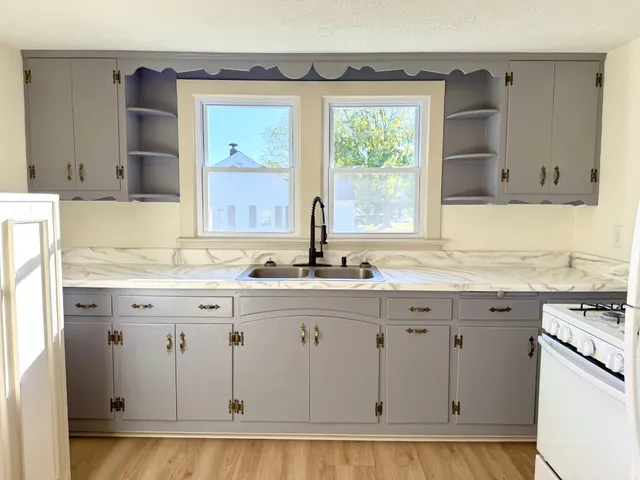 a bathroom with granite countertop a sink and a window