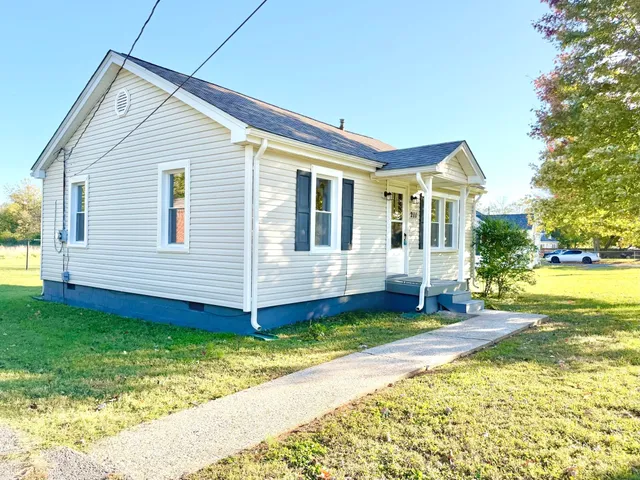 a view of a house with a yard and sitting area