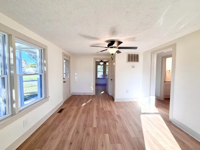 a view of a livingroom with wooden floor and a ceiling fan