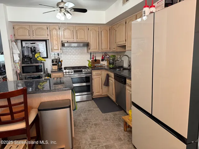 a kitchen with stainless steel appliances granite countertop a stove refrigerator sink and dishwasher