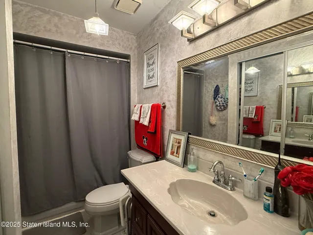 a bathroom with a sink vanity mirror and toilet
