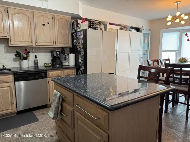 a kitchen with stainless steel appliances granite countertop a stove refrigerator and cabinets