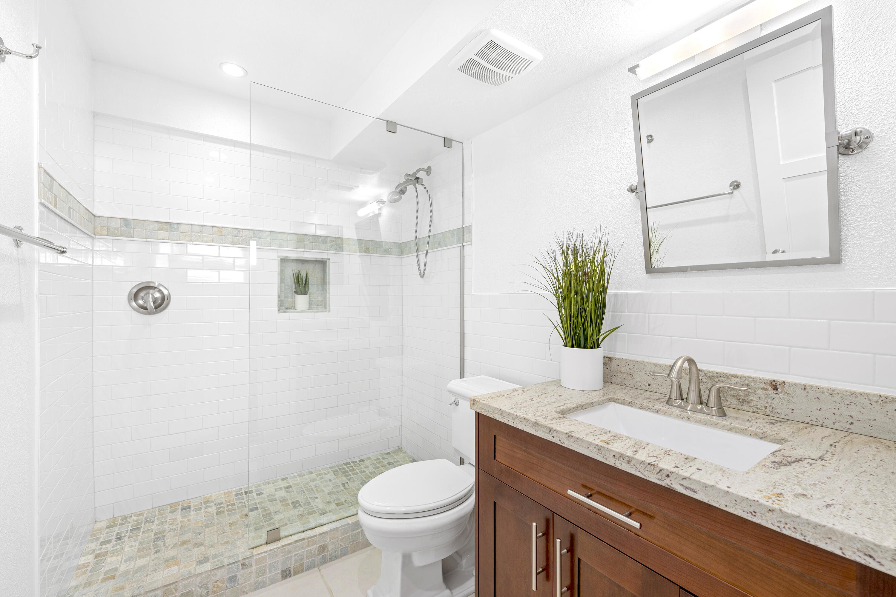 a bathroom with a granite countertop sink toilet and shower