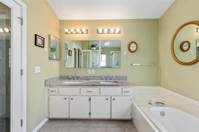 a bathroom with a granite countertop sink and a mirror a lamp