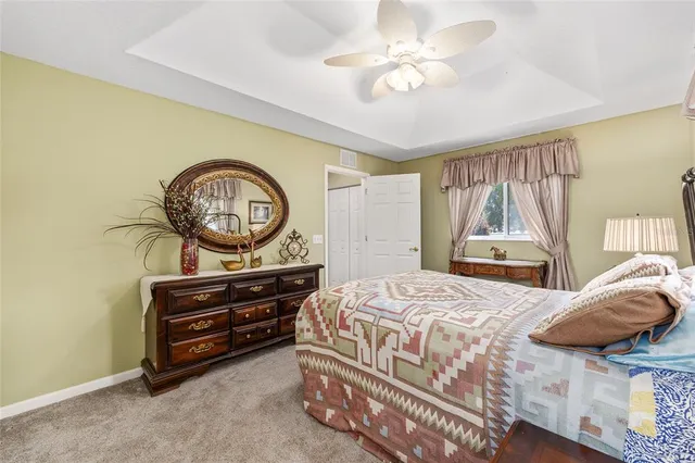 a bedroom with a bed a dresser and a chandelier