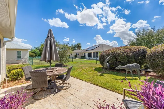 a view of backyard with a patio table and chairs