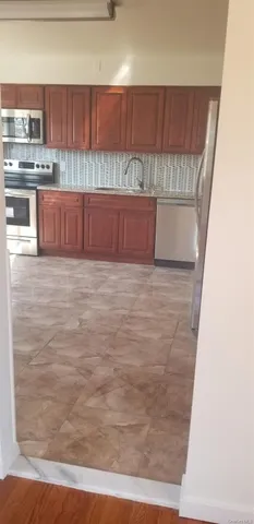 a view of kitchen with stainless steel appliances wooden floor