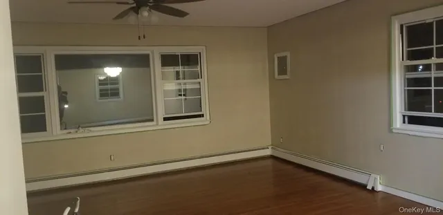 a view of empty room with windows and chandelier fan