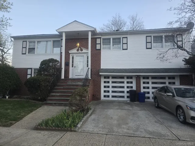 a view of a house with a barbeque and wooden fence