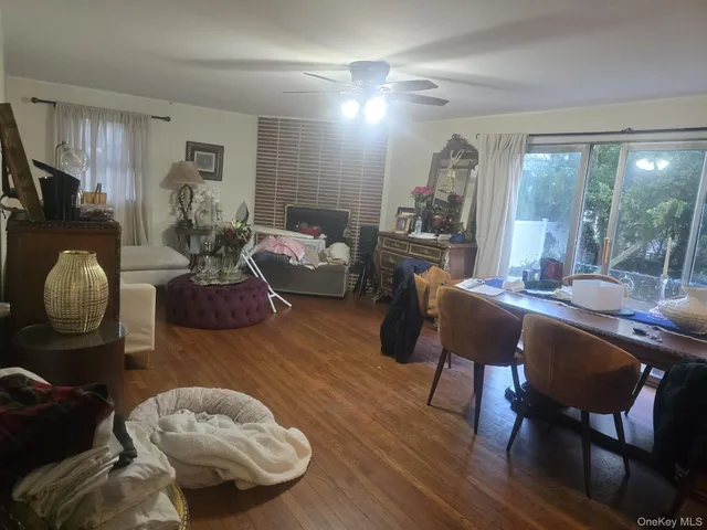 a living room with furniture a lamp wooden floor and a large window