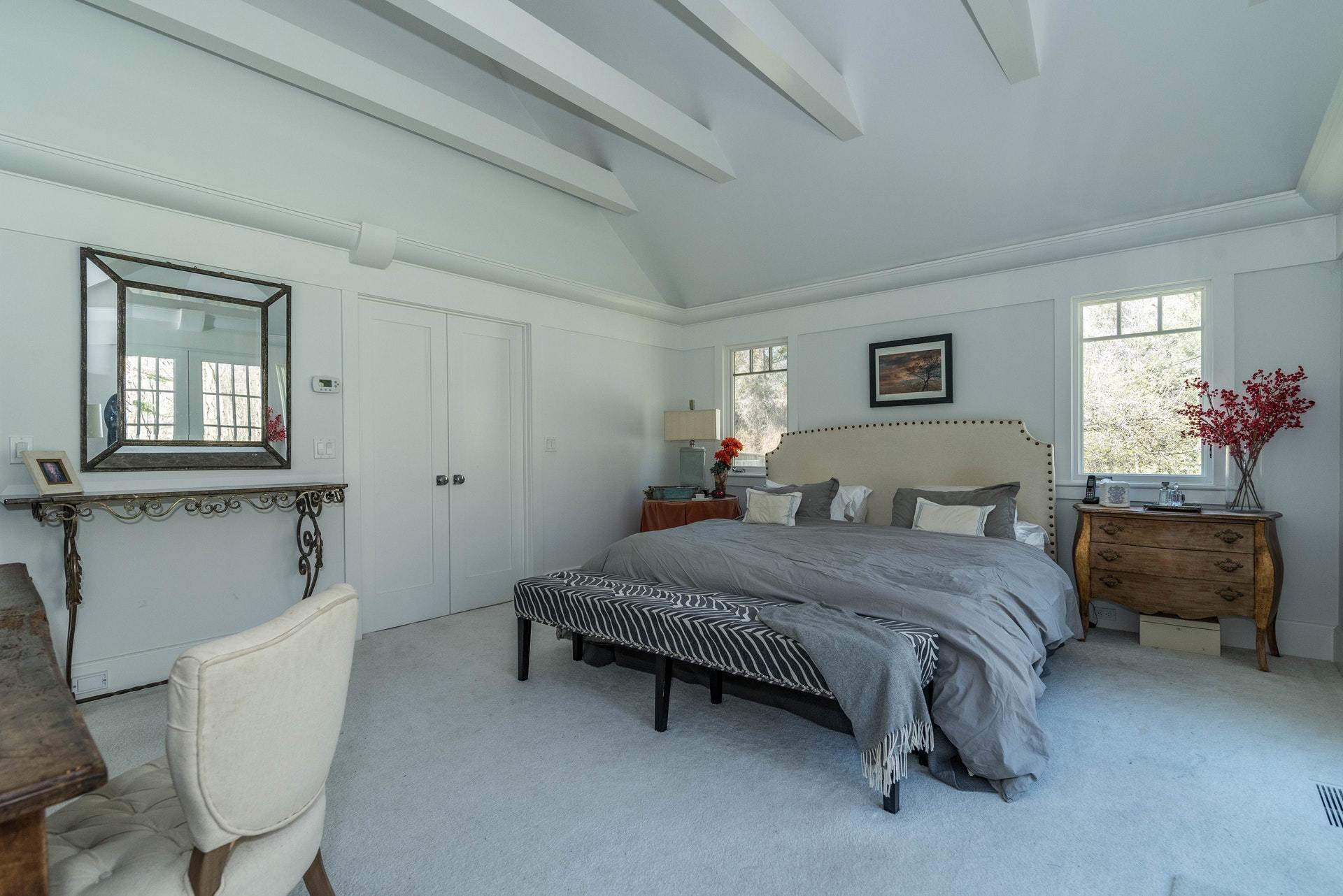 947 Valley Road New Canaan, CT 06840 - Photo 21 of 32 a spacious bedroom with a bed and a table chair