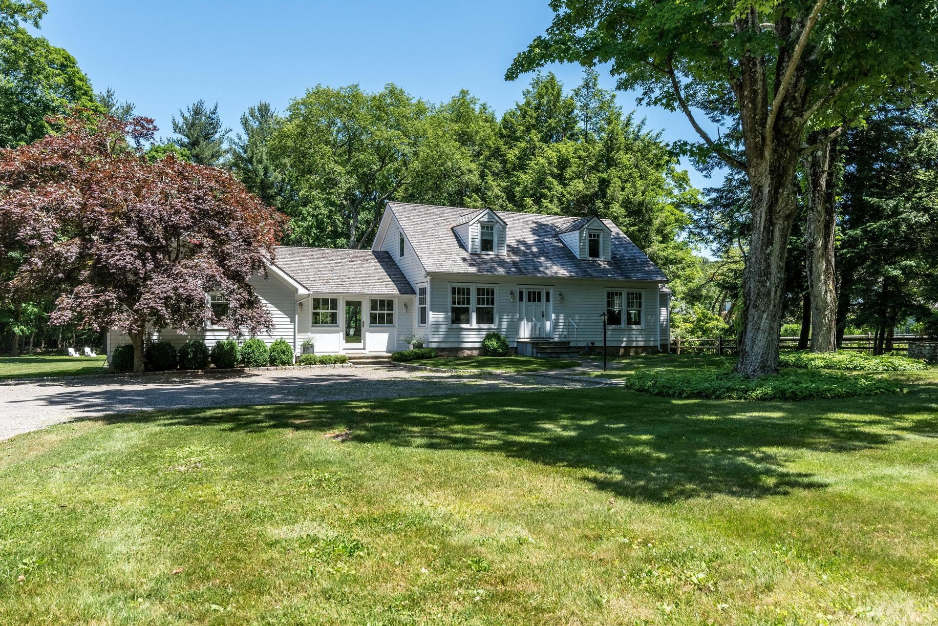 947 Valley Road New Canaan, CT 06840 - Photo 31 of 32 a front view of a house with a garden