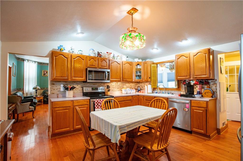166 Pennsylvania Avenue Rochester, PA 15074 - Photo 9 of 30 a kitchen with a table chairs refrigerator and microwave