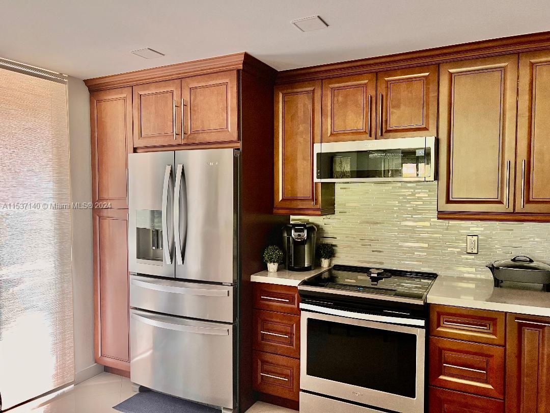 a kitchen with stainless steel appliances granite countertop a refrigerator stove and microwave