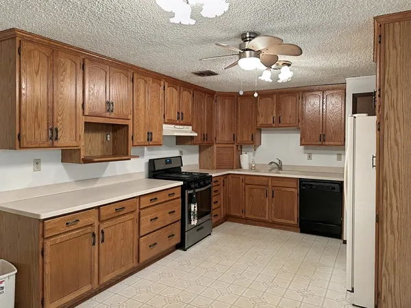a kitchen with kitchen island granite countertop stainless steel appliances sink cabinets and stove top oven