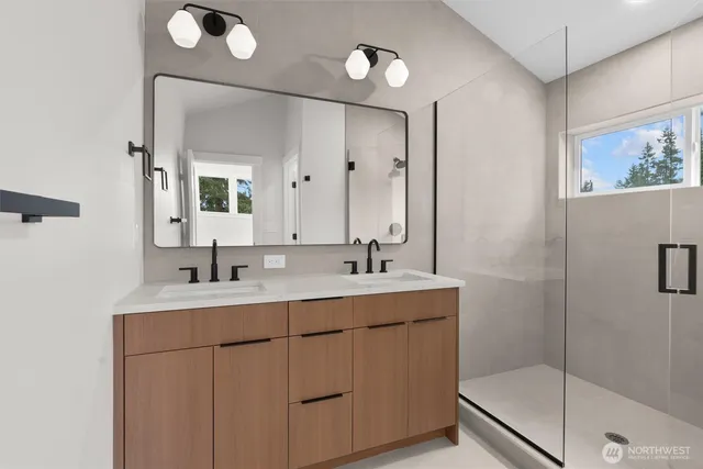 a bathroom with a double vanity sink mirror and shower