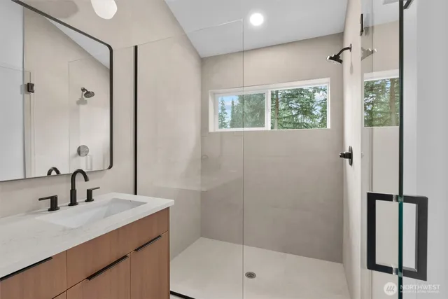 a bathroom with a shower sink and mirror