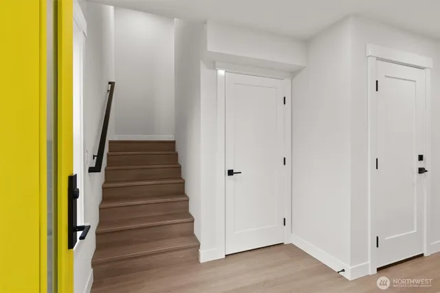 a view of a hallway with wooden floor and staircase