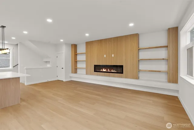 a view of an empty room with a fireplace and a window