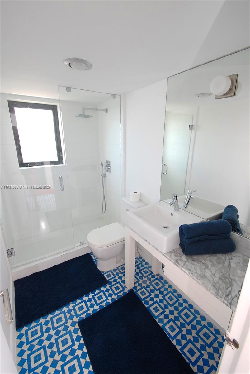 1800 Collins Avenue, Unit 18F Miami Beach, FL 33139 - Photo 12 of 22 a bathroom with a sink a toilet and shower